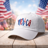 Classic white ‘Merica hat featuring bold red and blue embroidery on a rustic table.